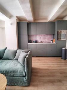 ein Wohnzimmer mit einem Sofa und einer Küche in der Unterkunft Confortable et cosy appartement en centre-ville in Aix-en-Provence