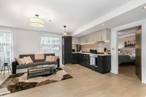 a living room with a couch and a kitchen at Modern 1 Bedroom Apartment in Woking Town Centre in Woking