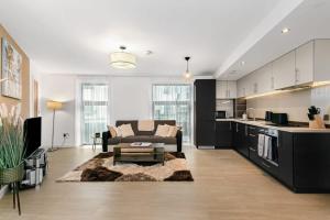 a living room with a couch and a kitchen at Modern 1 Bedroom Apartment in Woking Town Centre in Woking