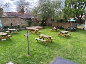 a group of picnic tables in a grassy yard at Three Tuns Ashwell in Ashwell