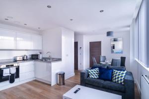 a kitchen and living room with a couch and a table at Spacious 1 Bed Old Trafford Apartment in Manchester