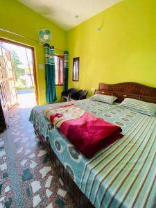 Himdarshan Homestay في Jageshwar: غرفة نوم بسرير كبير وبجدران صفراء
