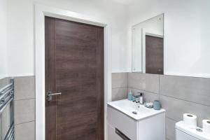 a bathroom with a wooden door and a sink at Spacious 1 Bed Old Trafford Apartment in Manchester