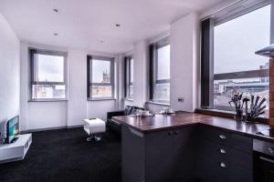 duże biuro z biurkiem i oknami w obiekcie Contemporary 1 Bed Apartment in Central Blackburn w mieście Blackburn
