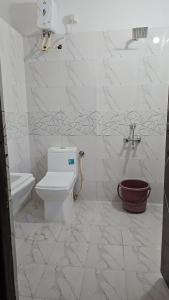 a white bathroom with a toilet and a sink at Ruchika's Orchid in Hyderabad