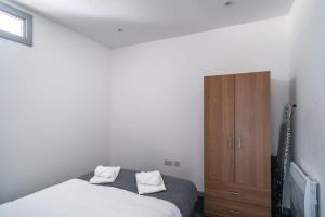 a bedroom with a bed and a wooden cabinet at Smart 1 Bedroom Apartment in Blackburn in Blackburn