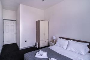 a bedroom with a white bed and a cabinet at Contemporary 1 Bed Apartment in Central Blackburn in Blackburn