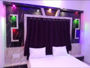 1 dormitorio con 1 cama con cortina negra en Hotel Raxaul King en Raxaul