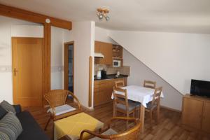ein Wohnzimmer mit einem Tisch und einer Küche in der Unterkunft Pension Terezka in Frymburk