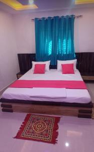 a bedroom with a large bed with a blue curtain at Hotel Raxaul King in Raxaul