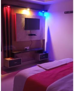 - une chambre avec un lit et une télévision murale dans l'établissement Hotel Raxaul King, à Raxaul