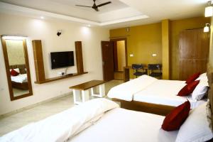 SānchiにあるShree Tara Heritageのベッド2台、薄型テレビが備わるホテルルームです。