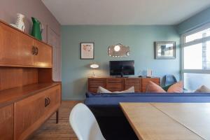 um quarto com uma cama e uma secretária com uma televisão em Centrally Located 4 Bedroom London Apartment em Londres