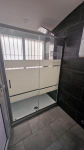 una cabina doccia in un bagno con porta in vetro di Costa rooms apartament a Livorno