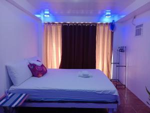 a bedroom with a white bed with a window at Zia Homestay in Burgos