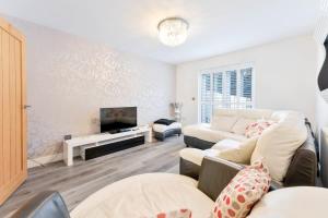 a living room with a couch and a tv at Modern 2 Bedroom House in Wolverhampton in Wolverhampton