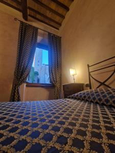 Un dormitorio con una cama grande y una ventana en La Locanda di Quercecchio, en San Gimignano