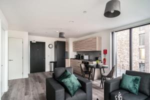 ein Wohnzimmer mit einem Sofa und einem Tisch sowie eine Küche in der Unterkunft Smart 1 Bedroom Apartment in Central Preston in Preston