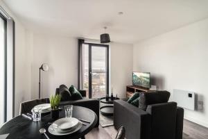 ein Wohnzimmer mit einem Tisch und einigen Stühlen in der Unterkunft Smart 1 Bedroom Apartment in Central Preston in Preston