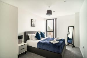 a bedroom with a bed and a mirror and a window at Stunning 2 Bedroom Apartment in Central Preston in Preston