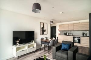 a living room with a couch and a dining room at Stunning 2 Bedroom Apartment in Central Preston in Preston
