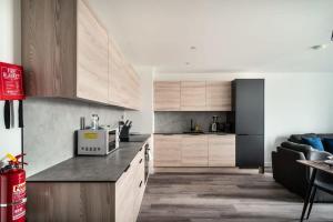 プレストンにあるStunning 2 Bedroom Apartment in Central Prestonのキッチン(木製キャビネット、カウンタートップ付)