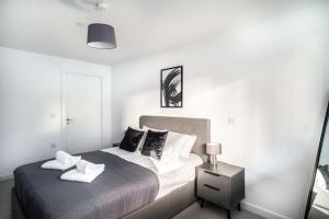 Stunning 2 Bed Apartment in Central Manchester في مانشستر: غرفة نوم عليها سرير وفوط