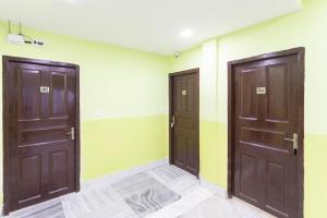 2 Türen in einem Zimmer mit grünen und gelben Wänden in der Unterkunft OYO Maple The Residence in Thākurdwari