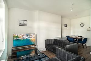 a living room with a couch and a flat screen tv at Spacious 2 Bed Apartment in Waterloo Liverpool in Waterloo