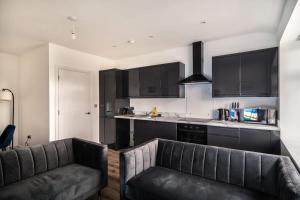 a kitchen with two leather couches and a kitchen counter at Spacious 2 Bed Apartment in Waterloo Liverpool in Waterloo