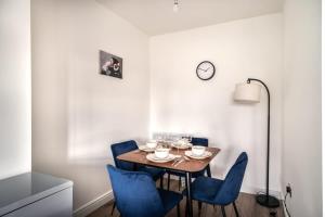 a dining room with a table and blue chairs at Spacious 2 Bed Apartment in Waterloo Liverpool in Waterloo