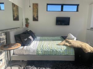 a bedroom with a bed with a table and a tv at Simply Stunning Studio 2 in Lake Tekapo