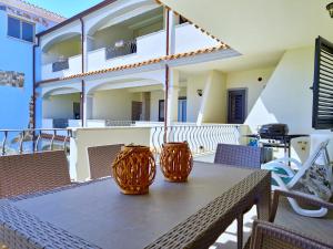 two orange vases sitting on a table on a balcony at Lux Limone - Appartamenti in residence con piscina in Orosei