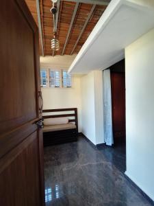 een hal met een deur en een bank in een kamer bij Brindaven in Mysore