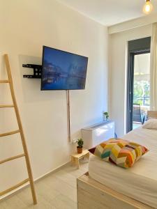 a bedroom with a bed and a flat screen tv on the wall at Phos Luxury Apartment in Lefkada