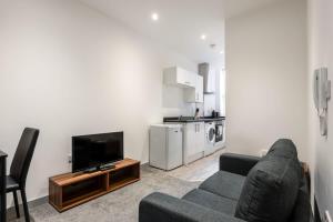 a living room with a couch and a television at Lovely 1 Bed Budget Apartment in Central Doncaster in Doncaster