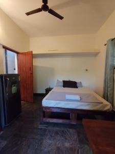 um quarto com uma cama e uma ventoinha de tecto em Brindaven em Mysore
