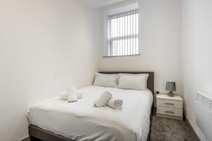 um quarto com uma cama branca e toalhas em Lovely 1 Bed Budget Apartment in Central Doncaster em Doncaster