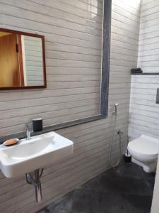 uma casa de banho com um lavatório e um WC em Brindaven em Maiçor