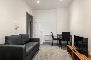 uma sala de estar com um sofá e uma mesa em Lovely 1 Bed Budget Apartment in Central Doncaster em Doncaster