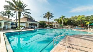 una piscina en un complejo con palmeras en The Cute Condo, en Kissimmee