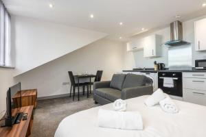 a kitchen and a living room with a bed and a couch at Smart Budget Studio Apartment in Central Doncaster in Doncaster