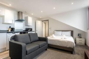 a bedroom with a bed and a couch and a kitchen at Smart Budget Studio Apartment in Central Doncaster in Doncaster