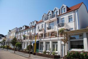 a row of white buildings on a street at Hotel Friese-up AnnerSiet- in Norderney
