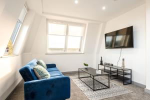 a living room with a blue couch and a tv at Modern 1 Bedroom Apartment in Central Hull in Hull