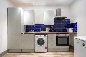 una cucina con lavatrice e piastrelle blu di Smart 1 Bed Budget Apartment in Darlington a Darlington