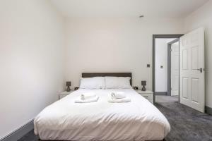 una camera da letto con un letto bianco con due asciugamani di Smart 1 Bed Budget Apartment in Darlington a Darlington