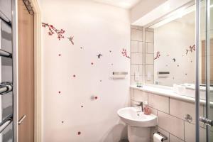 ein weißes Badezimmer mit einem Waschbecken und einem Spiegel in der Unterkunft Spacious & Modern 1 Bed Apartment Manchester in Manchester