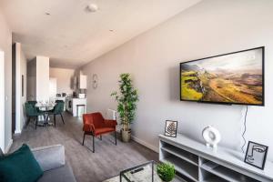 een woonkamer met een tv aan de muur bij Modern & Spacious 2 Bed Apartment in Waterloo Liverpool in Waterloo