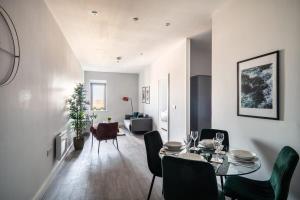 een eetkamer en een woonkamer met een tafel en stoelen bij Modern & Spacious 2 Bed Apartment in Waterloo Liverpool in Waterloo